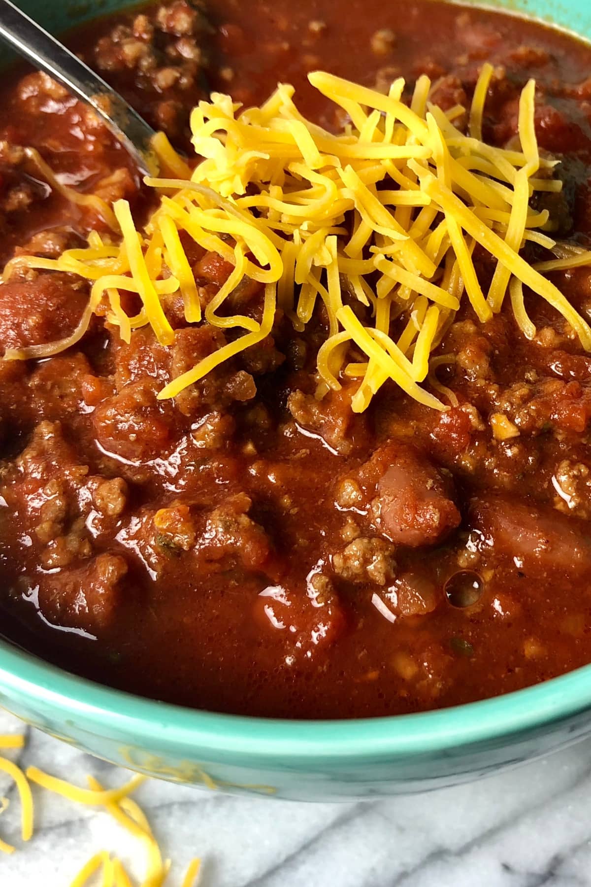 Homemade Chili with Ground Beef and Shredded Cheese in a Colorful Bowl