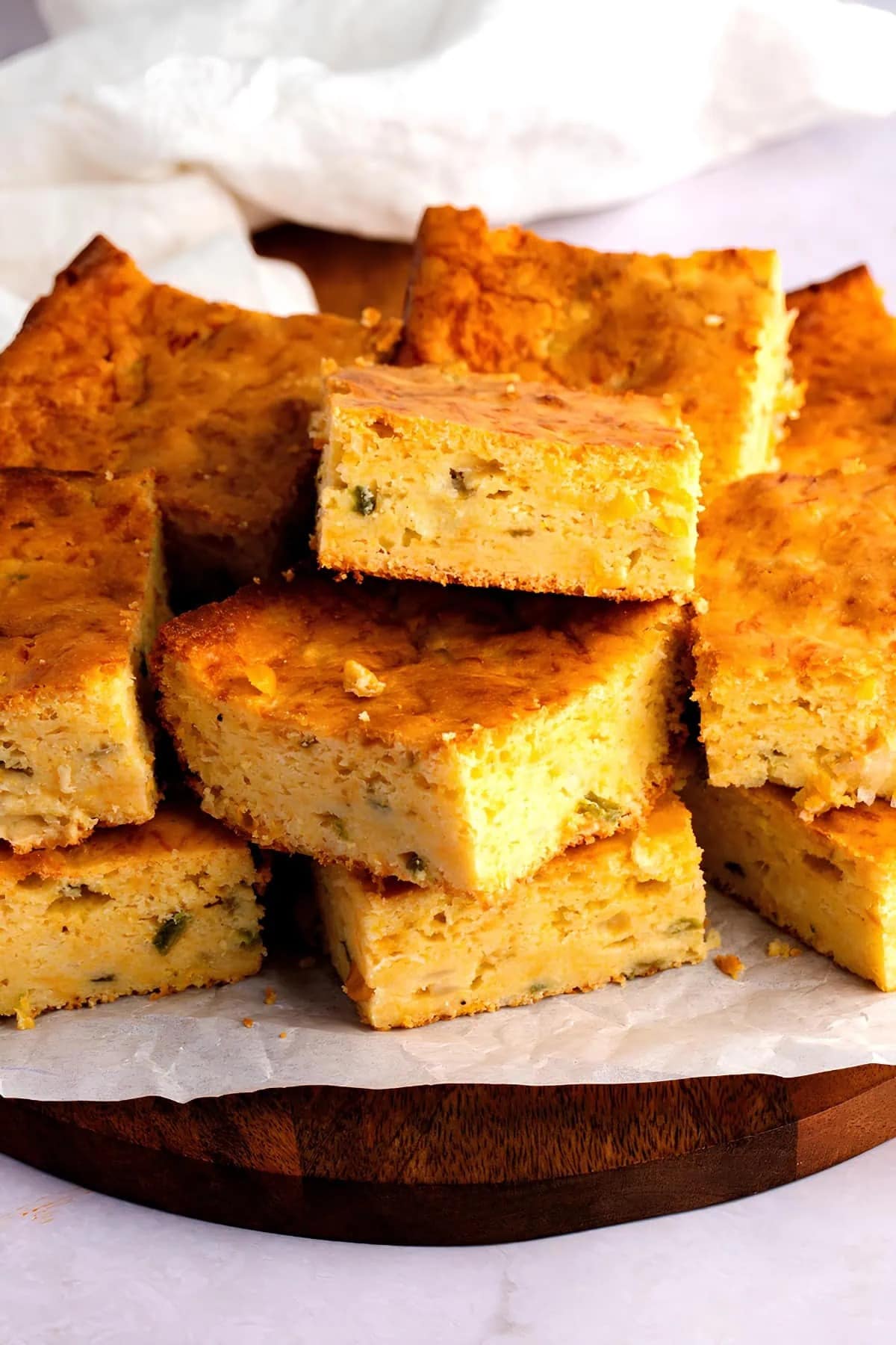 Stacks of Spicy Mexican Cornbread with Jiffy Mix on a cutting board with parchment paper