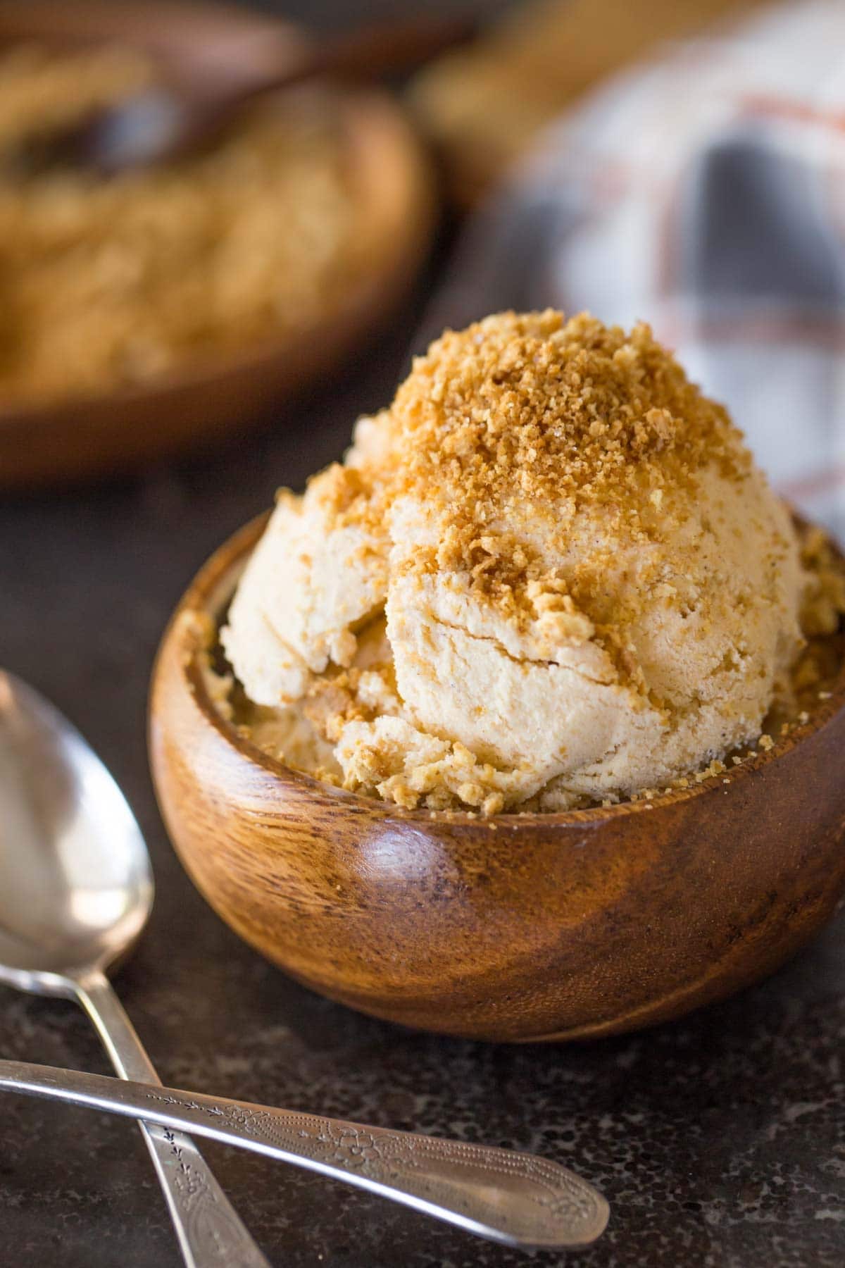 Pumpkin pie ice cream in a wooden bowl sprinkled with cinnamon. 