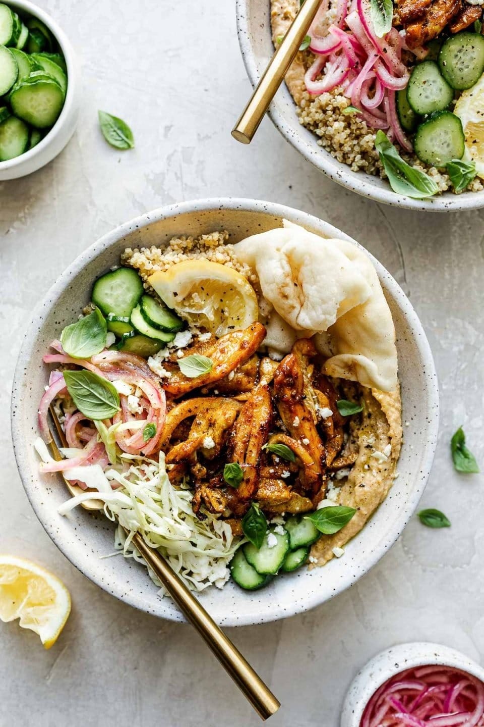 Chicken and hummus salad in a bowl made with fluffy grains, creamy hummus, seasoned chicken, and crunchy veggies. 