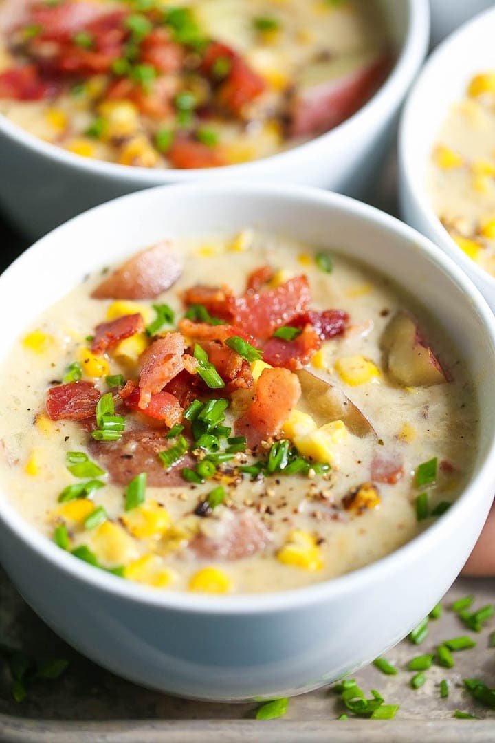 Bowls of homemade Instant Pot Corn Chowder with chopped chives and diced bacon on top