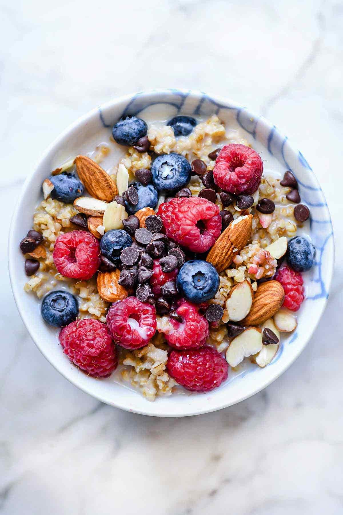 Instant pot oatmeal in a bowl with loads of berries and nuts. 
