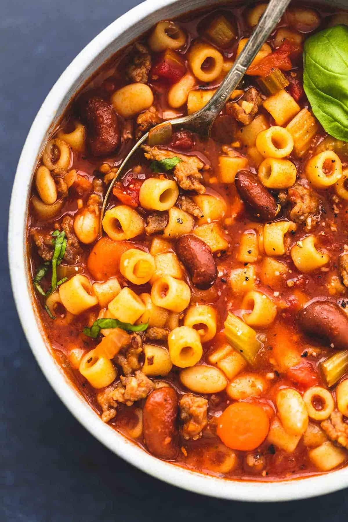 Spoon scooping on a bowl of Instant Pot Pasta e Fagioli Soup with Italian sausage, carrots, diced tomatoes, ditalini pasta, navy and red kidney beans