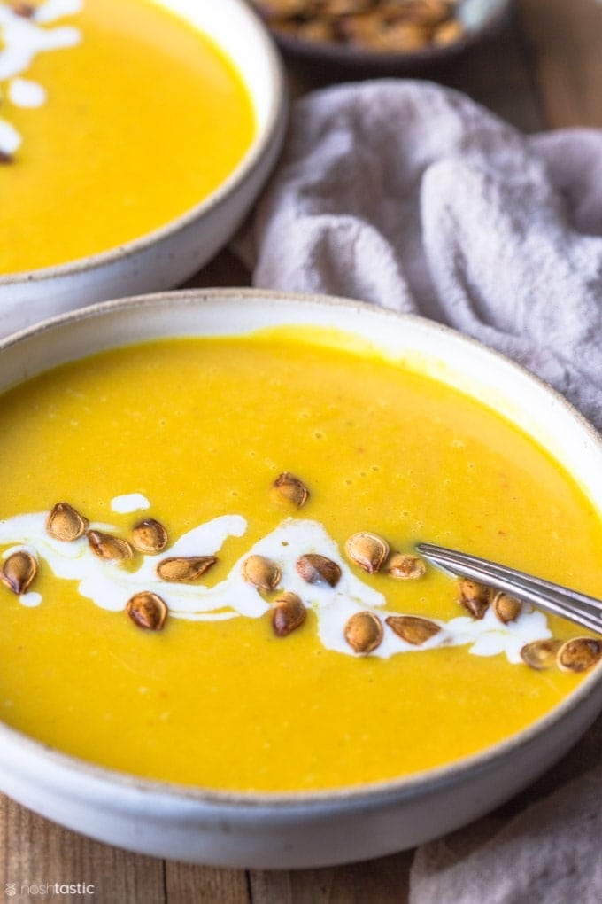 Bowls of homemade Instant Pot Pumpkin Soup with coconut milk and garnished with pumpkin seeds