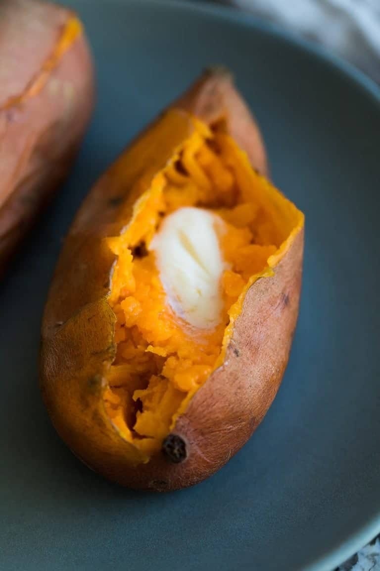 Cooked sweet potatoes sliced in half with butter. 