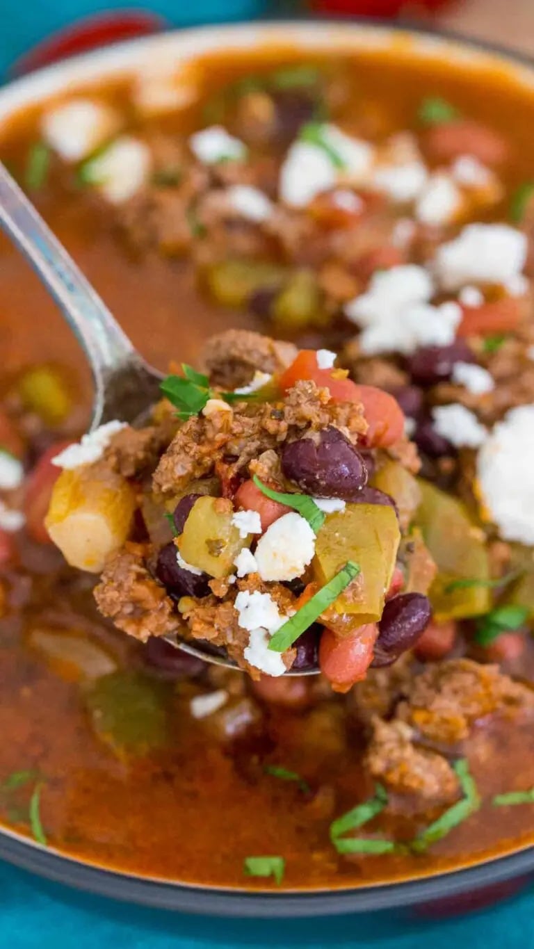 Spoon scooping on a bowl of Instant Pot Taco Soup with ground beef, diced tomatoes, green chilis, black and red beans