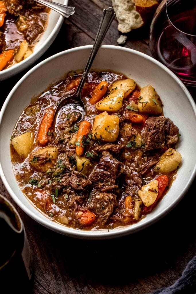 Beef stew in a bowl with carrots, potatoes and veggies. 