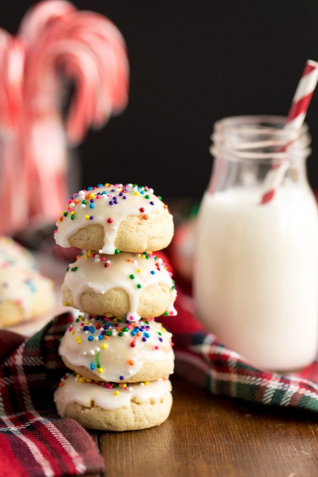 Stack of Italian anisette cookies with white frosting an d sprinkles on top. 