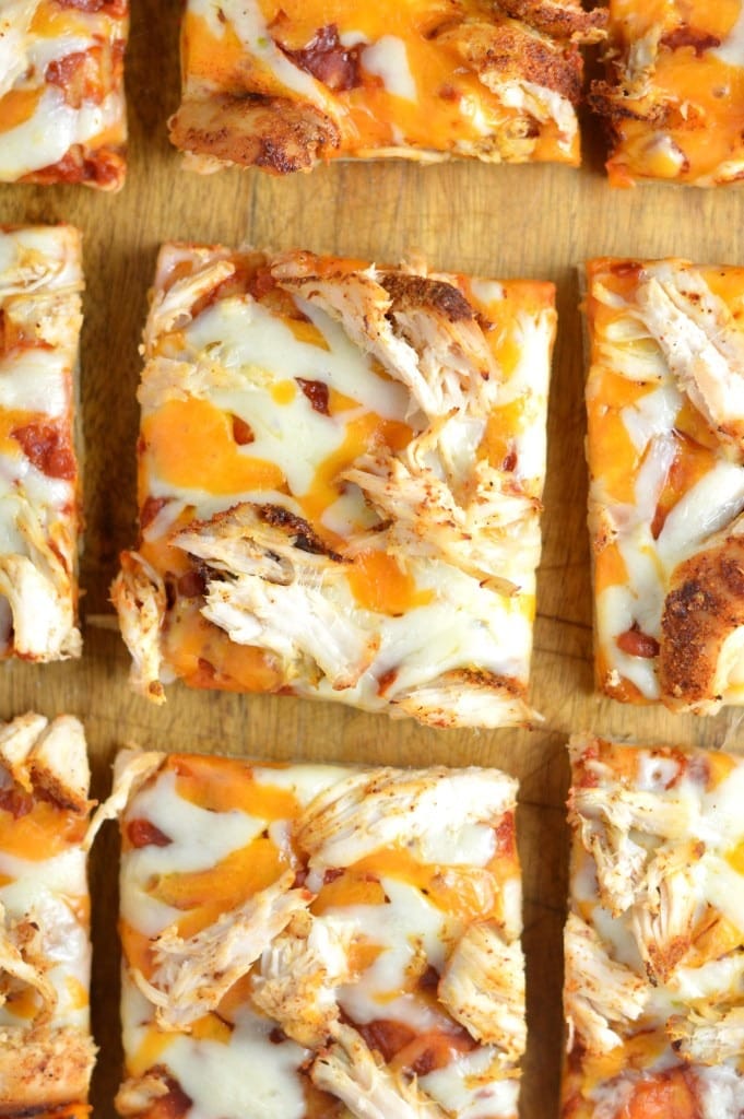 Sliced leftover chicken flatbread pizza on a wooden cutting board. 
