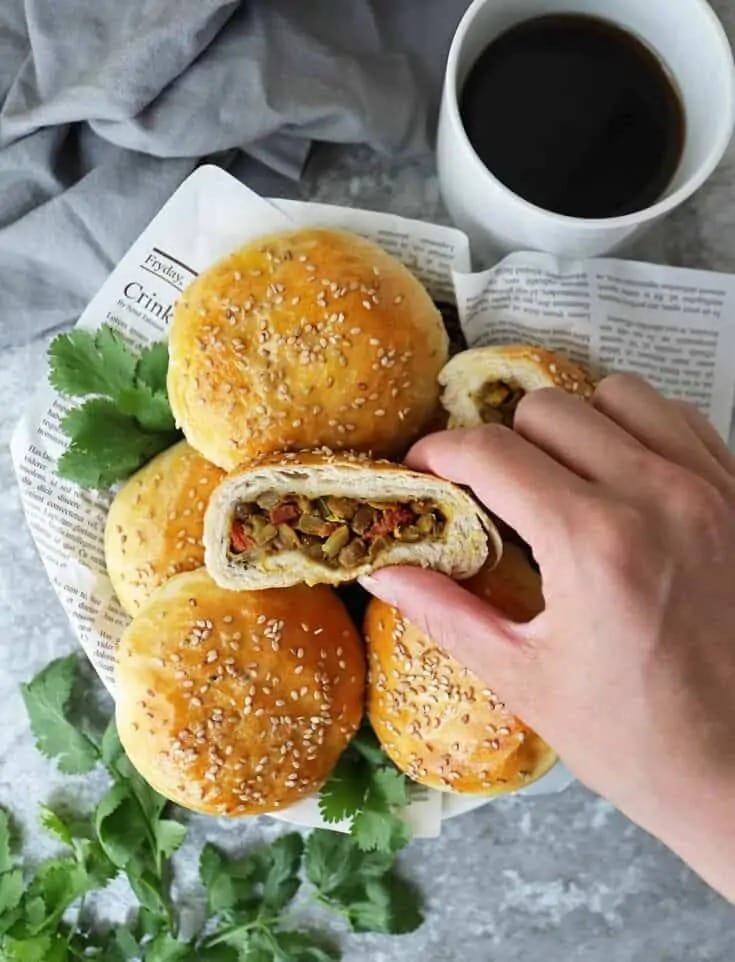 Bunch of lentil stuffed buns on top of a newspaper. 