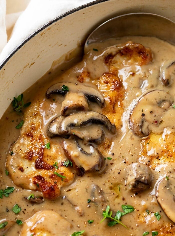 Chicken and mushrooms in creamy sauce cooking in a pan
