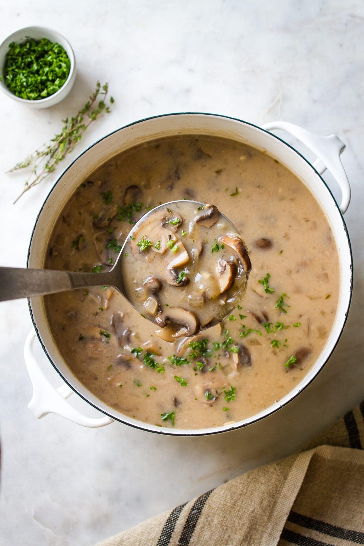 Pot of homemade Mushroom Soup with coconut milk, vegan cream and garnished with parsley