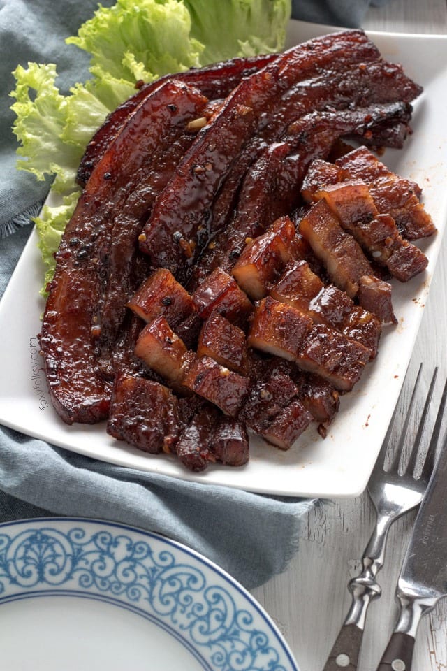 Oven Roasted BBQ Pork Belly with lettuce on a serving dish