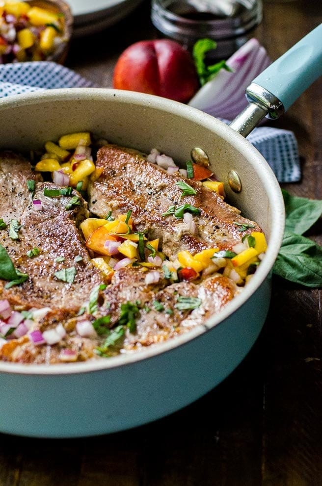 Pork chops cooked with fruits and herbs on a pan. 