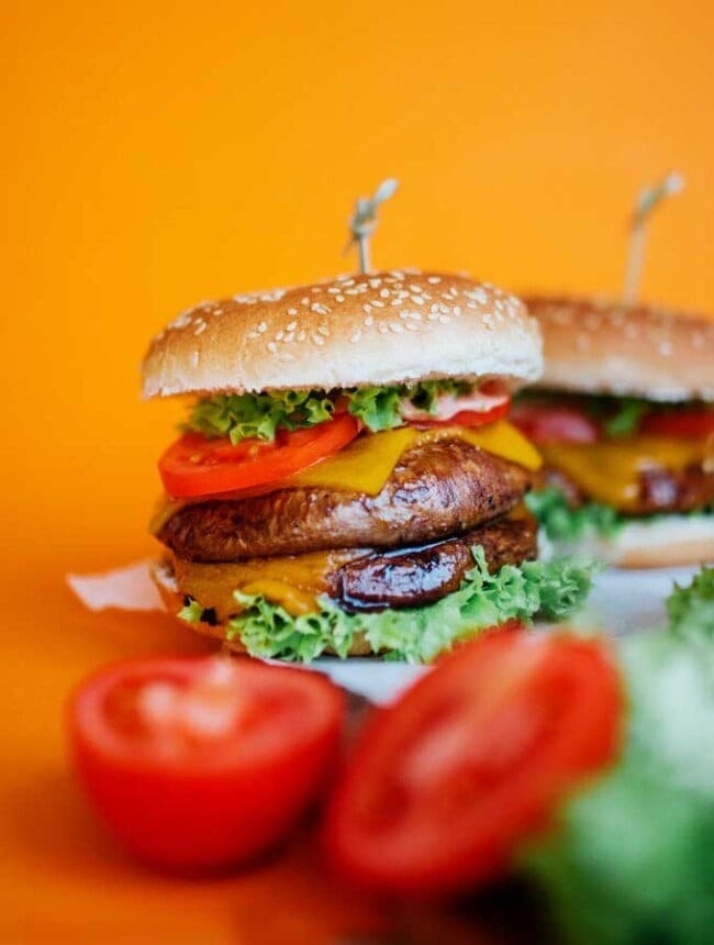 Portobello mushroom burgers made with thick patties, tomato slices, cheese and lettuce. 