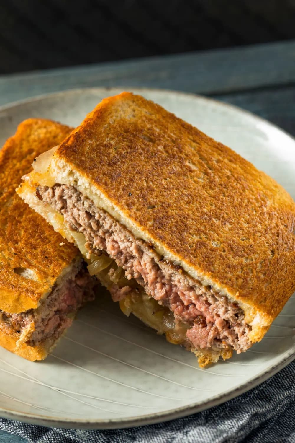 Sliced in half classic patty melt on a plate. 