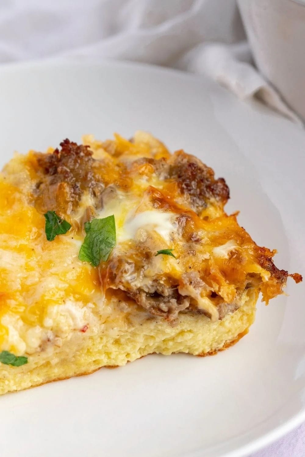 Slice of crustless egg casserole with sausage and cheese served on a plate