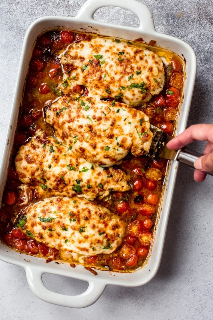Baked Pesto Chicken with Tomatoes and Mozzarella in a White Casserole