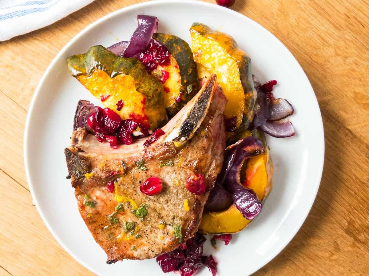 Pork chop served with acorn squash and cranberries. 