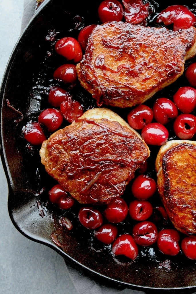Pork Chops with Cherries and Bourbon cooked in a skillet. 