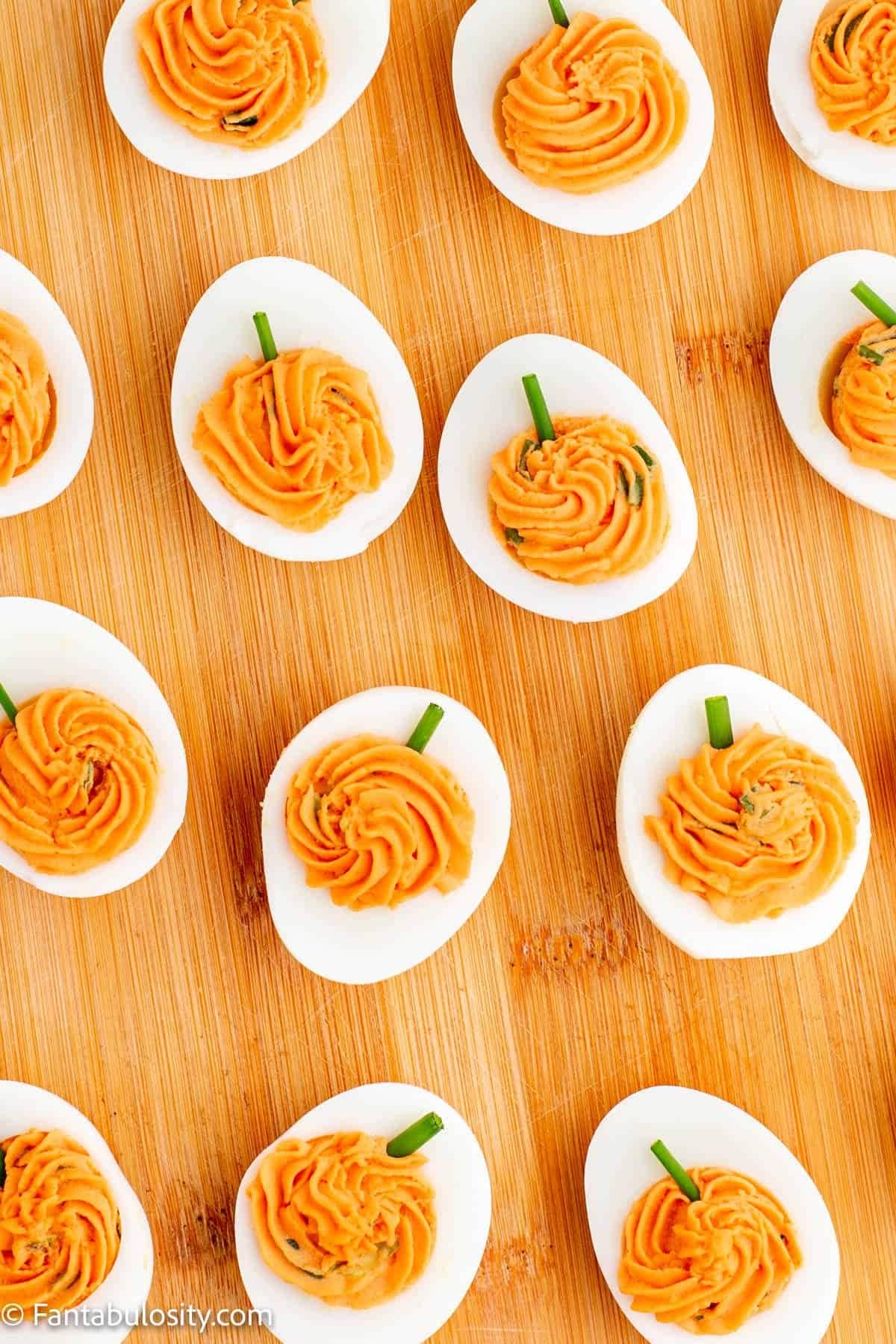 Boiled eggs sliced in half decorated with pumpkin cream in the middle. 