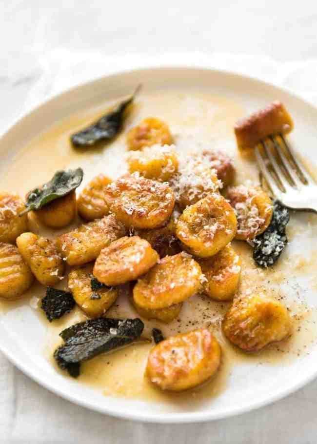 Pumpkin gnocchi with sage butter sauce on a plate. 