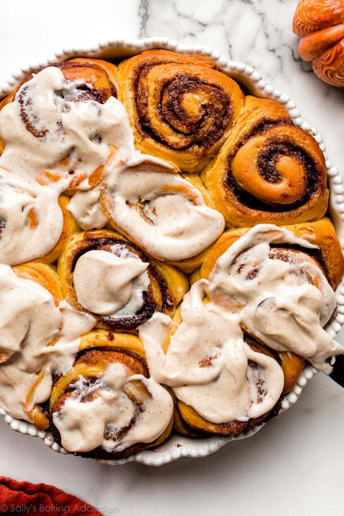 Pumpkin cinnamon rolls with cream frosting spread on top. 