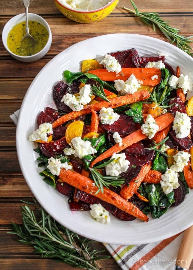 Roasted beets and carrots salad with burrata on a plate. 