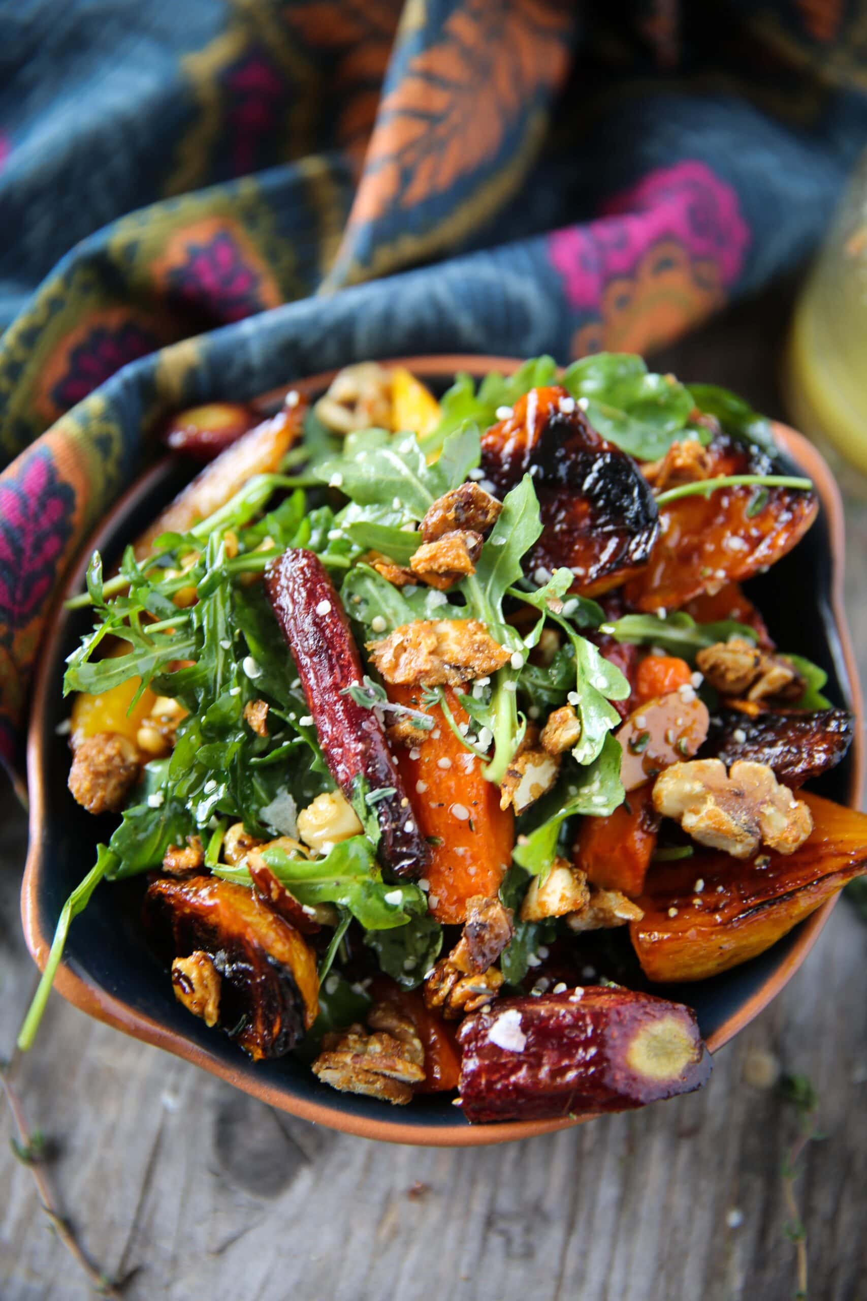 Bowl of homemade Roasted Beet & Carrot Salad with almonds. walnuts and arugula