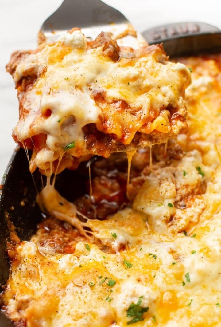 Cheesy skillet lasagna scooped with a spatula, 