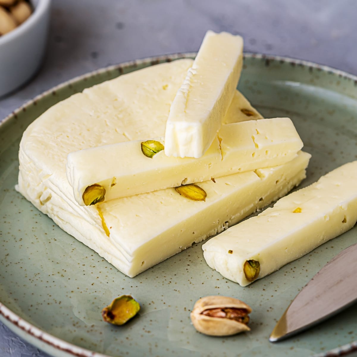 Sliced Asiago Cheese with Pistachio Nuts in a Plate