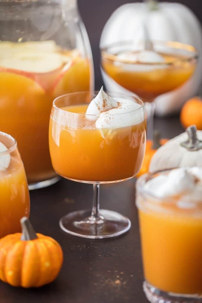 Pumpkin pie punch served on glasses topped with whipped cream and cinnamon powder. 