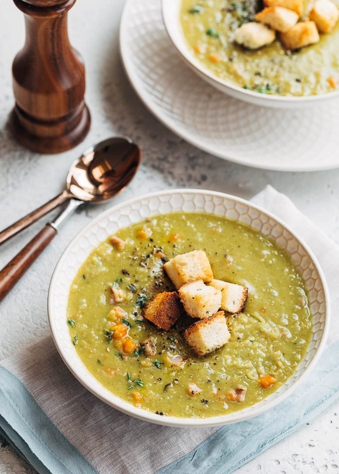 Split pea soup served in a bowl topped with croutons and spices. 