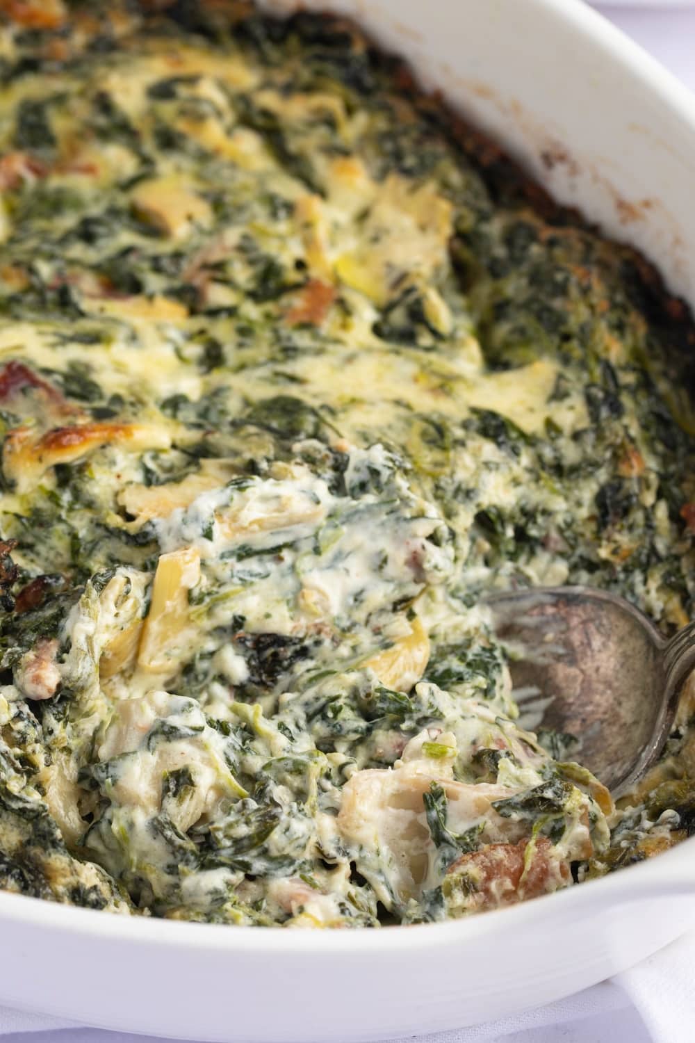 Spoon Scooping Spinach Artichoke Dip on a casserole
