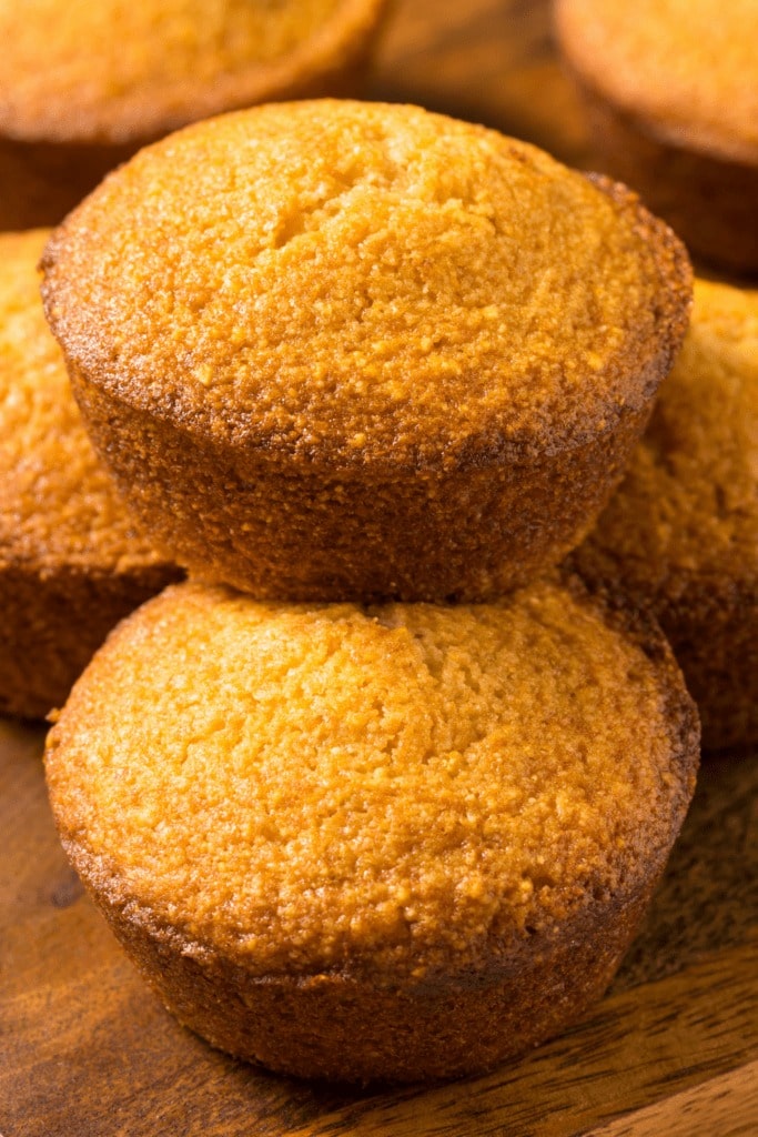 Stack of Jiffy cornbread muffins on a dark wooden table. 