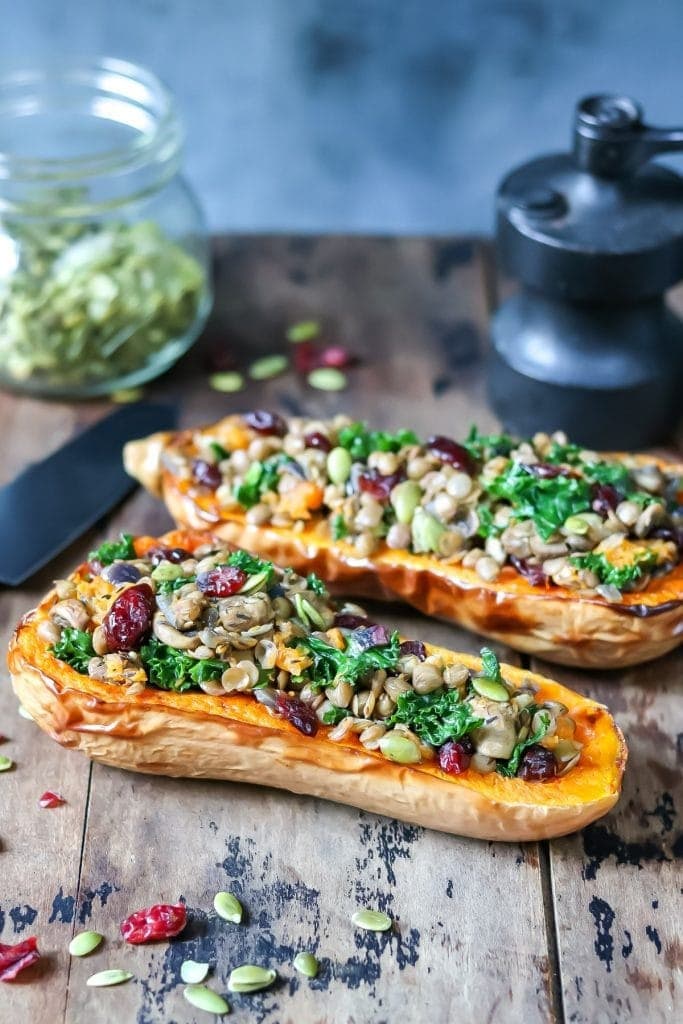 Stuffed butternut squash on top of wooden table. 