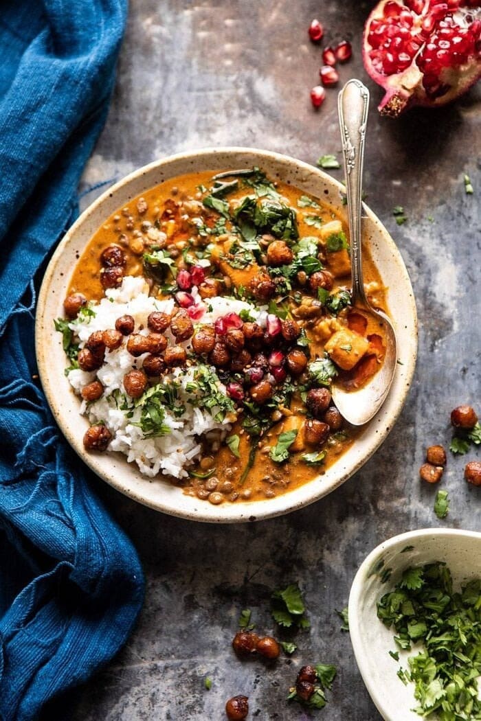Sweet potato lentil curry with crispy sesame chickpeas on a bowl with spoon. 