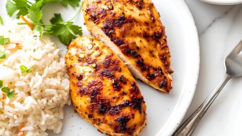 Tender Homemade Chicken Breast with Rice on a White Plate