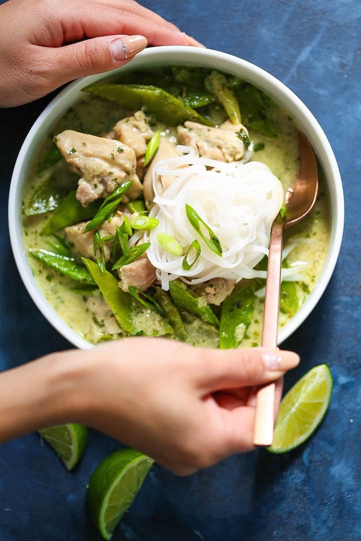 Bowl of homemade Thai Green Curry Soup with rice noodles, chicken breast, green curry paste, green onions, cilantro, ginger, snow peas and coconut milk