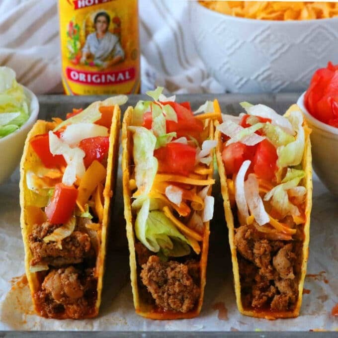 Tacos with ground turkey filling topped with cheese, tomatoes and lettuce. 