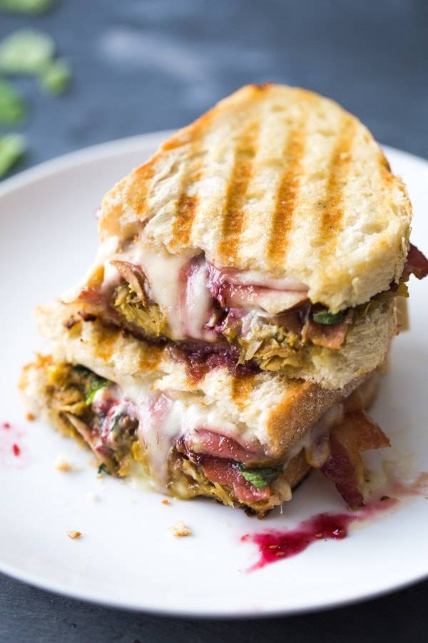 Plate with grilled Leftover Turkey Panini sandwich filled with meat and cheese.