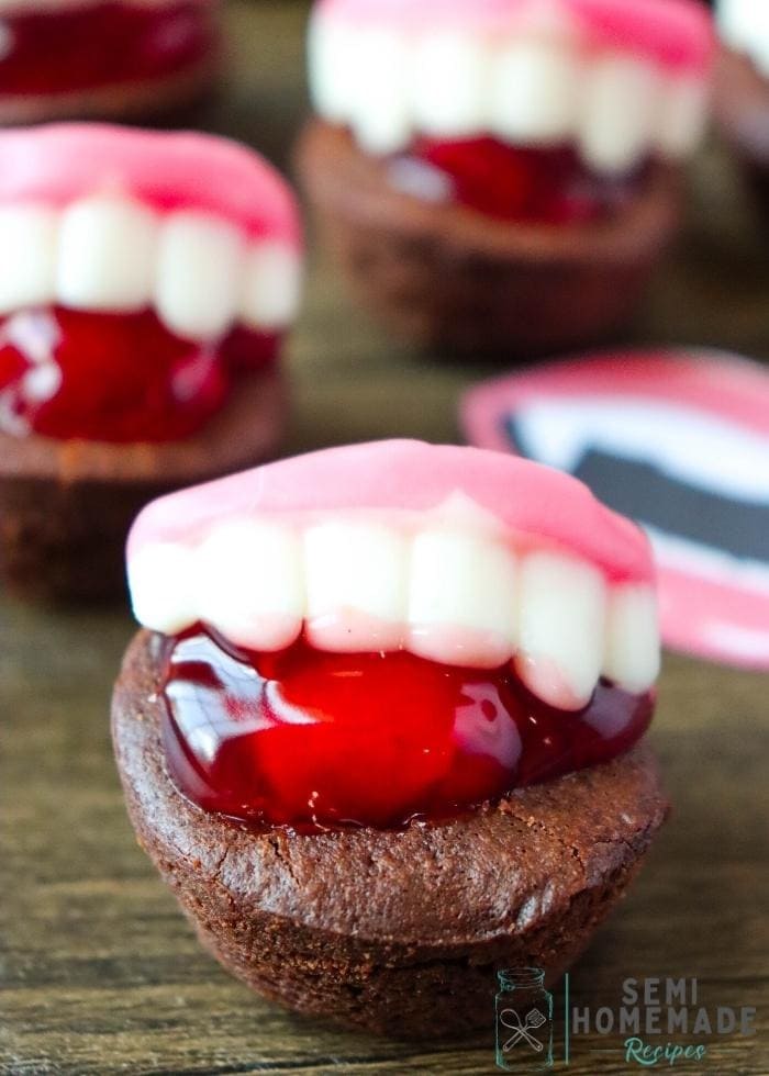 Brownie topped with red cream and a mouth shaped candy.