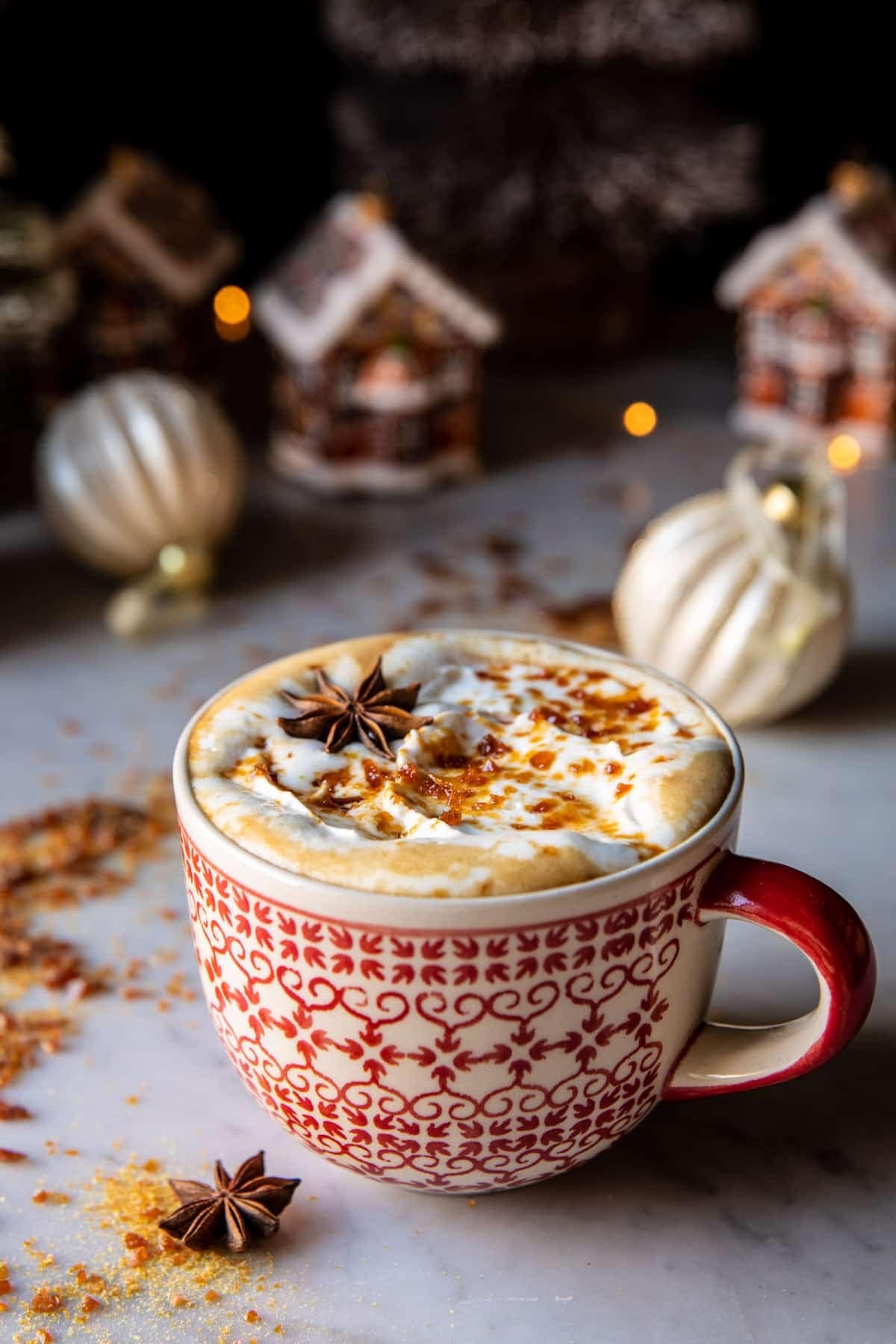 Vanilla gingerbread latte on a red pattern mug opped with a sweet caramel brulee.