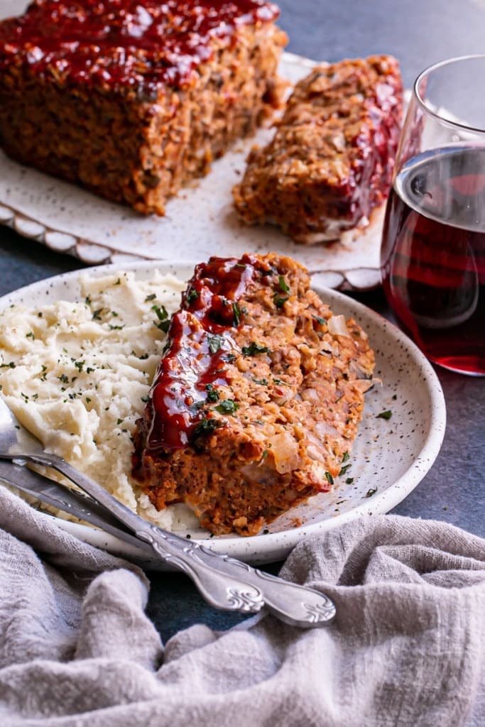 Sliced meatloaf served with mashed potato on a plate. 