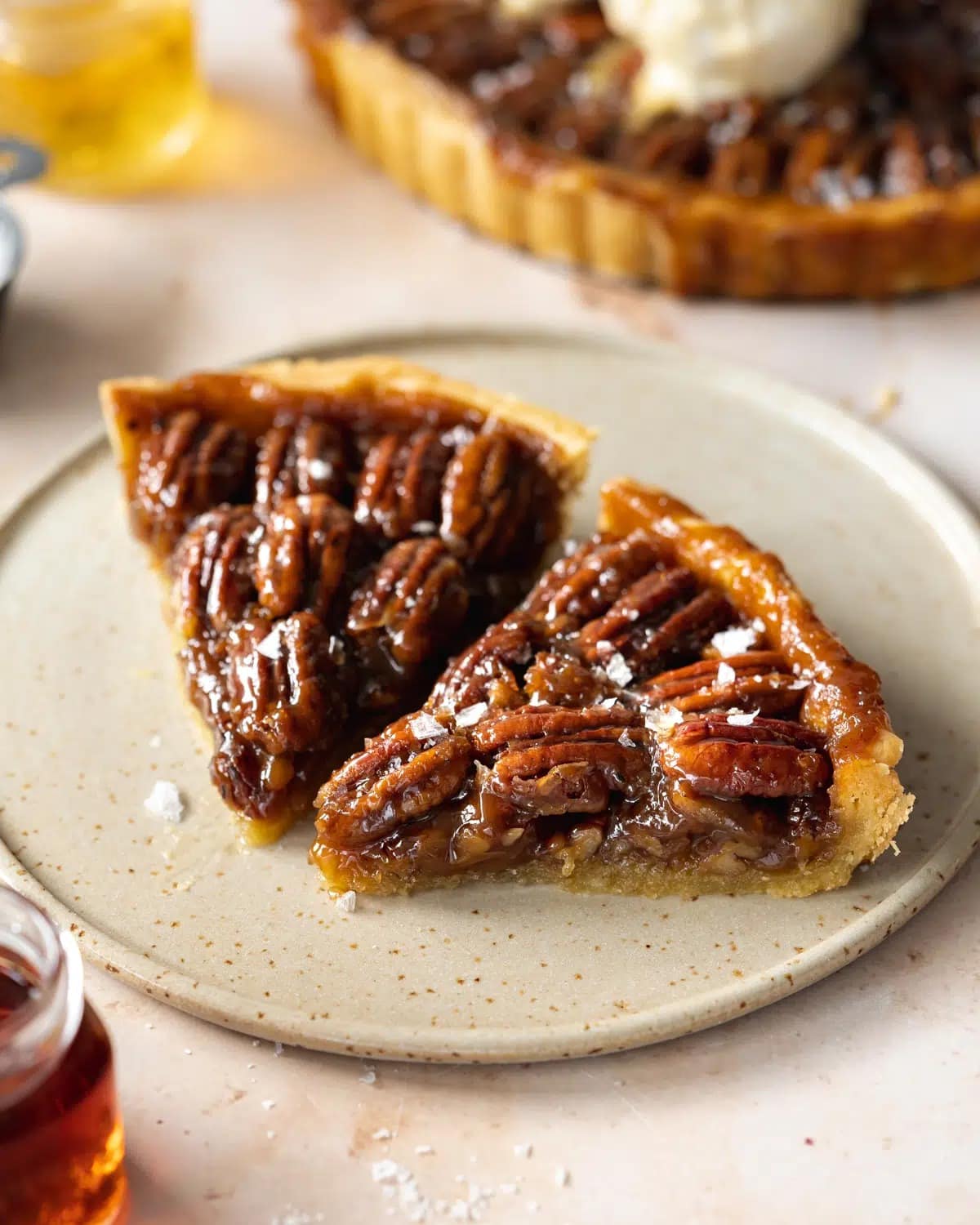 Two slices of pecan pie on a plate. 