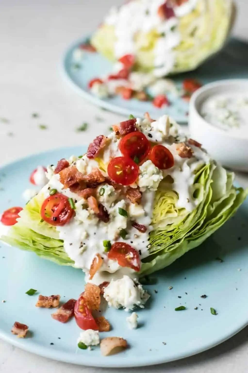 Wedge salad made with a slice of cabbage topped with salty bacon, sweet tomatoes and a rich blue cheese dressing.