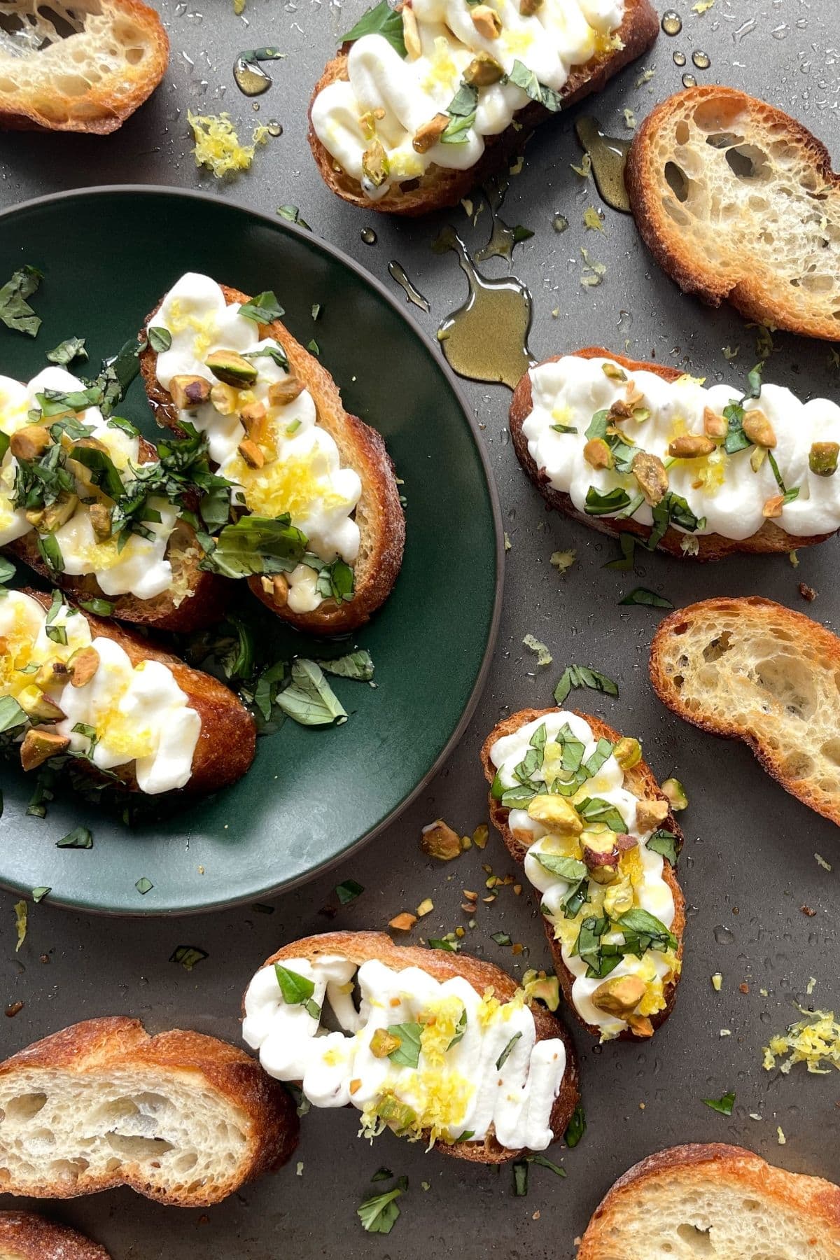 Crostini slices topped with whipped ricotta garnished with pecans, lemon zest. 