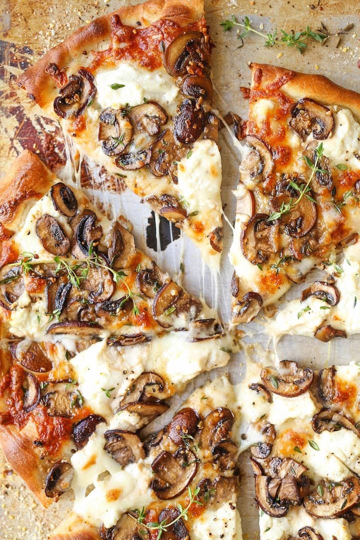 Sliced white mushroom pizza topped with gooey cheese and herbs. 