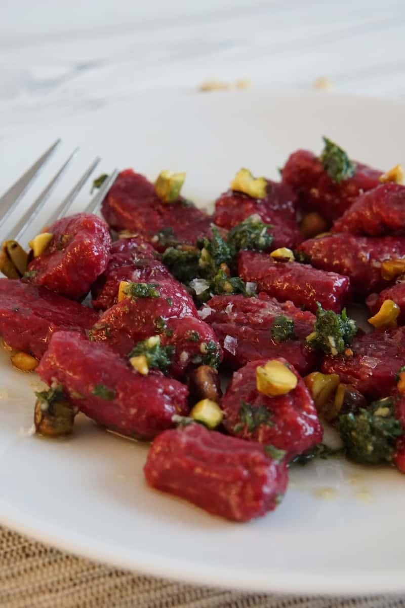 Beet gnocchi on a white plate. 