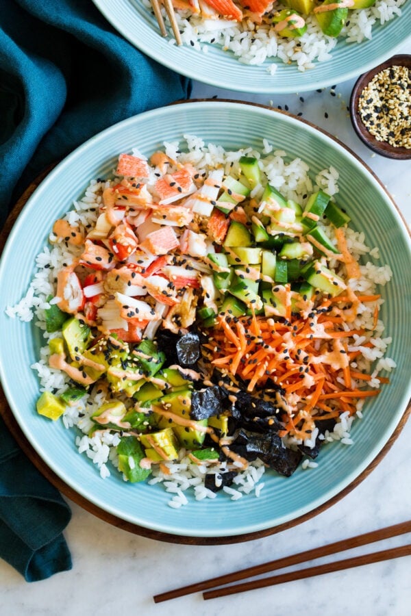 Rice bowl topped with crabmeat, nori, fresh vegetables, avocado, and creamy sriracha mayo.